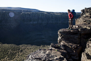 Eine Frau mit einem Rucksack steht oberhalb von Frenchman's Coulee, Washington. - AURF03804