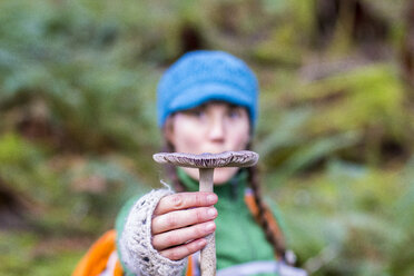 Eine Frau hält einen frisch gepflückten Pilz im Hoh Rainforest, WA, hoch - AURF03807