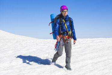 Eine Frau durchquert ein Schneefeld im Grand Teton National Park, Wyoming. - AURF03857