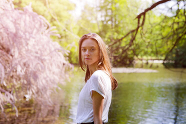 Porträt einer attraktiven jungen Frau an einem Teich - GIOF04297
