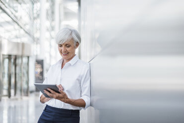 Smiling senior businesswoman using tablet - DIGF05020