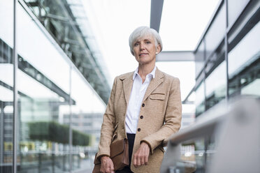 Portrait of confident senior businesswoman leaning on railing in the city - DIGF05050