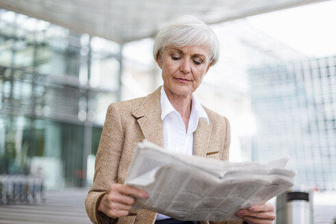 Ältere Geschäftsfrau in der Stadt liest Zeitung - DIGF05059