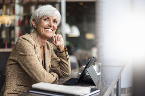 Porträt einer lächelnden älteren Geschäftsfrau mit Tablet in einem Café - DIGF05104