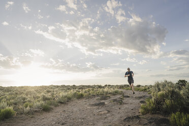 Man trail running through sagebrush desert, Taos, New Mexico, USA - AURF03930