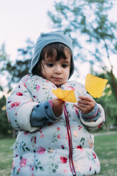 Portrait of fashionable little girl with yellow autumn leaves - GEMF02408