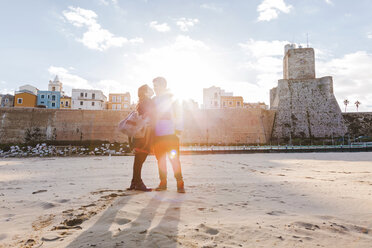 Italien, Molise, Termoli, junges Paar am Strand bei Sonnenaufgang - FLMF00019