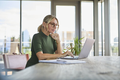 Reife Frau benutzt Laptop auf Tisch zu Hause - RBF06507