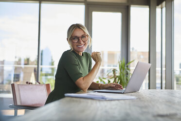 Portrait of smiling mature woman using laptop on table at home - RBF06509