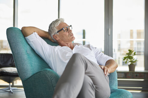 Mature man relaxing in armchair at the window at home - RBF06516