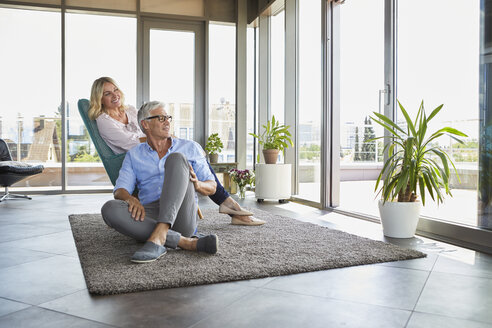 Mature couple relaxing at home looking out of window - RBF06541