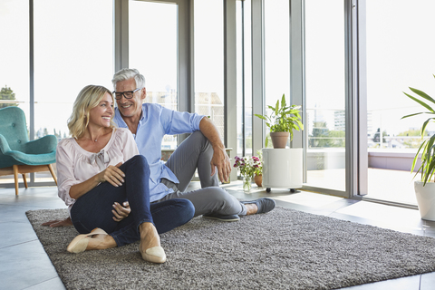 Smiling mature couple relaxing at home stock photo