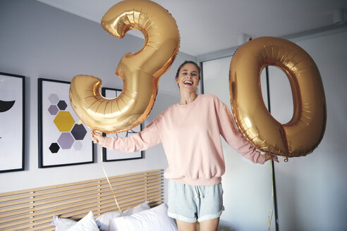 Porträt einer fröhlichen Frau mit goldenen Luftballons, die ihren Geburtstag feiert - ABIF00964