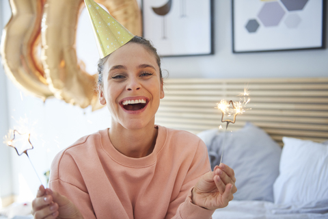 Fröhliche Frau an ihrem Geburtstag mit Wunderkerzen, lizenzfreies Stockfoto