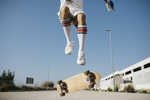 Sportlicher Mann, der mit einem Skateboard über den Boden springt und einen Trick vorführt - JRFF01849