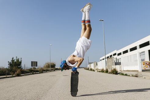 Man in stylish sportive outfit standing on skateboard upside down - JRFF01854