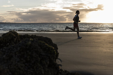 Jogger running on he beach at sunset - UUF15050