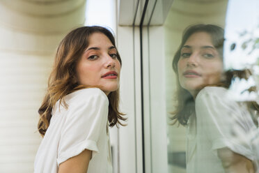 Young woman posing in front of glass screen - KKAF01659