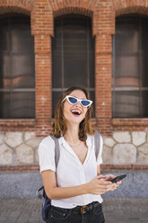 Young woman sight seeing in Madrid, using smartphone - KKAF01691