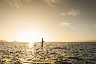 Junge Frau Stand Up Paddle Surfing bei Sonnenuntergang - UUF15077