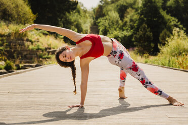 Young woman practicing Pilates in an urban park - NMSF00225