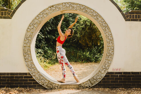 Young woman practicing Pilates in an urban park - NMSF00234