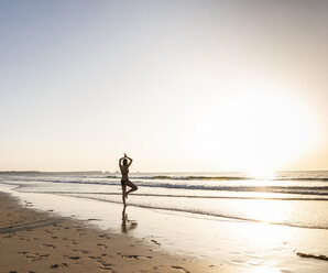 Junge Frau übt Yoga am Strand - UUF15138