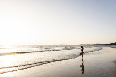 Junge Frau übt Yoga am Strand - UUF15140