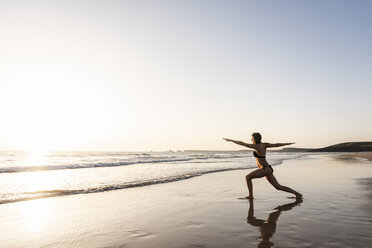 Junge Frau übt Yoga am Strand - UUF15141