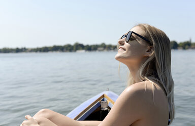 Deutschland, Brandenburg, lächelnde blonde Frau beim Sonnenbad am Zeuthener See - BFRF01896