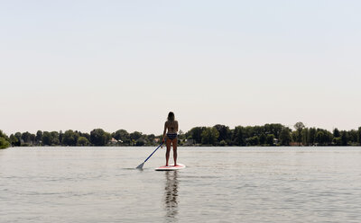 Deutschland, Brandenburg, Rückenansicht einer Frau beim Stand Up Paddle Surfen auf dem Zeuthener See - BFRF01897