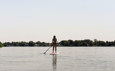 Germany, Brandenburg, back view of woman stand up paddle surfing on Zeuthener See - BFRF01897