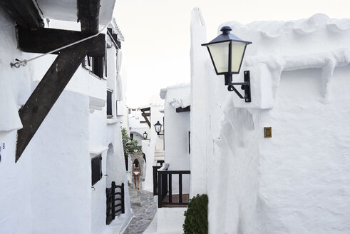 Spanien, Menorca, Binibequer, Rückenansicht einer Frau in einer Gasse - IGGF00585