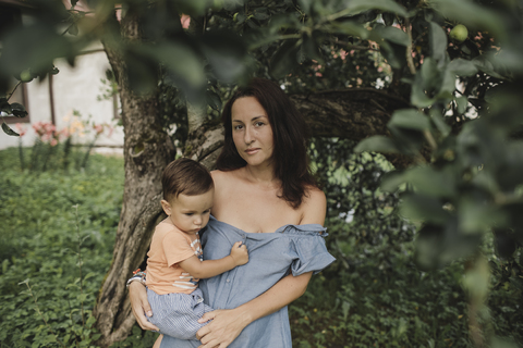 Porträt einer Mutter mit Baby im Garten, lizenzfreies Stockfoto