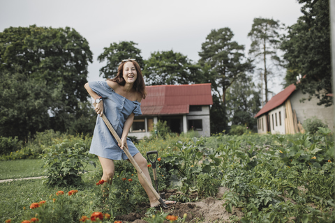 Porträt einer glücklichen Frau bei der Arbeit im Garten, lizenzfreies Stockfoto
