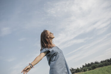 Relaxed woman on a rural field - KMKF00565