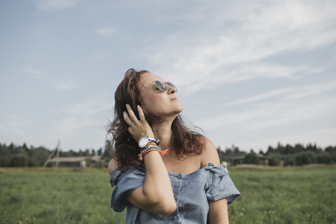 Entspannte Frau auf einem ländlichen Feld, lizenzfreies Stockfoto