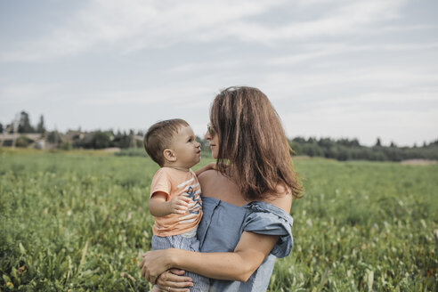 Mutter hält Baby auf einem Feld - KMKF00572