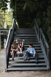 Friends with skateboard relaxing on stairs outdoors - MAUF01683