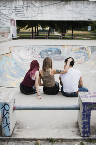 Rückansicht von Freunden, die im Skatepark sitzen, lizenzfreies Stockfoto