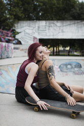 Happy friends sitting in skatepark - MAUF01707