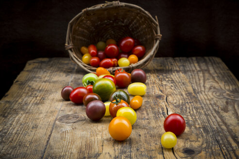 Korb mit Heirloom-Tomaten auf Holz - LVF07422