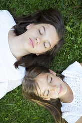 Two sisters resting together on a meadow - LVF07437