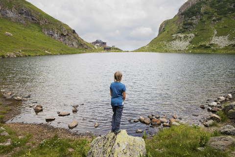 Österreich, Tirol, Fieberbrunn, Wildseeloder, Mädchen steht am Ufer des Wildsees, lizenzfreies Stockfoto