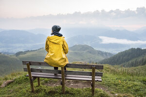 Austria, Tyrol, Fieberbrunn, Wildseeloder, woman sitting on bench with view on mountainscape - PSIF00068