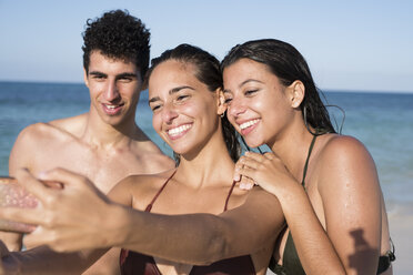 Glückliche Freunde machen Selfies am Strand - PACF00090