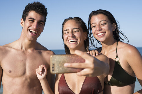 Glückliche Freunde machen Selfies am Strand - PACF00091