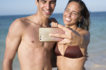 Glückliches junges Paar macht Selfies am Strand - PACF00093