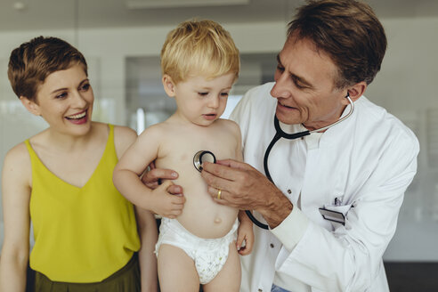 Kinderarzt untersucht Kleinkind mit Stethoskop, Mutter steht daneben - MFF04457