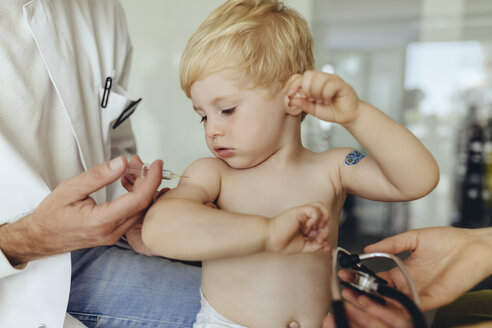 Pediatrician vaccinating toddler, injecting infant's arm - MFF04460